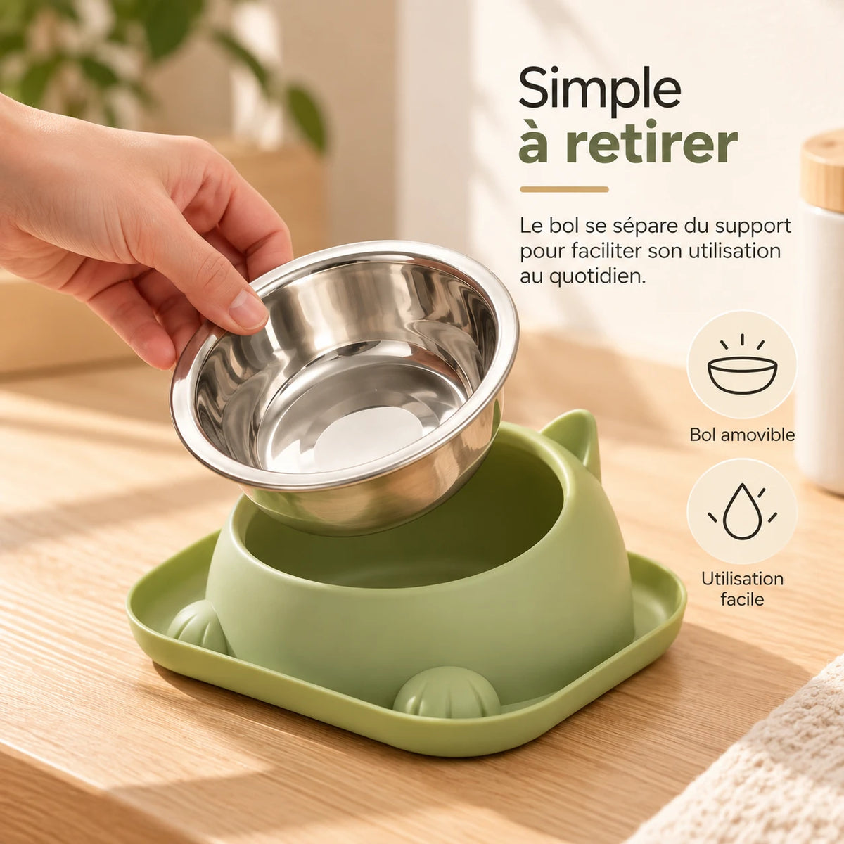Une main soulève le bol en inox hors de son socle, pour le lavage